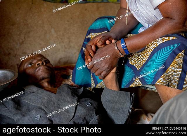 Sister Marie Stella comforting Jean, a 42-year-old man dying of AIDS in his home place. Vivre dans l'Esperance (living with hope) NGO