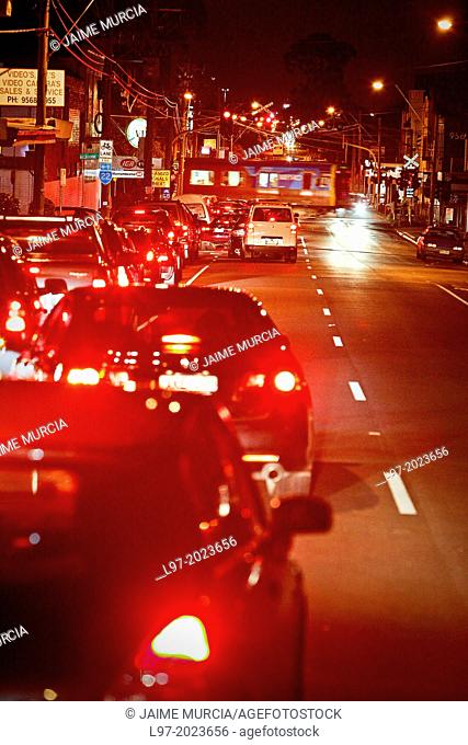 Traffic congestion at railway crossing, red tail lights of cars, Melbourne Australia