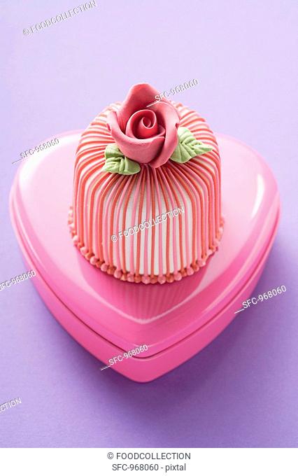 Marzipan-covered cake on pink chocolate box