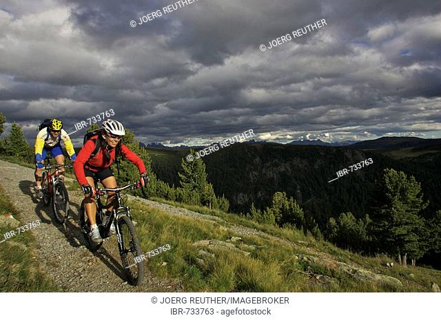 Male and female mountain bikers at Gedrum alpine pasture in the Dolomites, Sarentino, Bolzano-Bozen, Italy, Europe