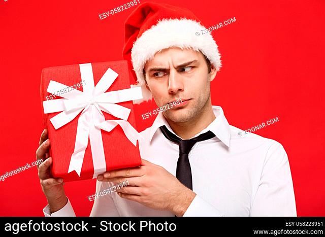Christmas Concept - portrait close-up Santa christmas businessman over red background holding red gift