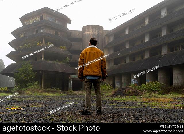 Rear view of man standing at abandonded building, Sao Miguel Island, Azores, Portugal