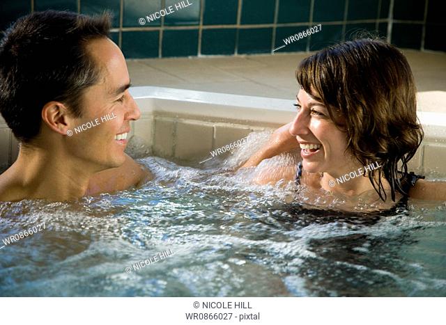 Man and woman in hot tub smiling