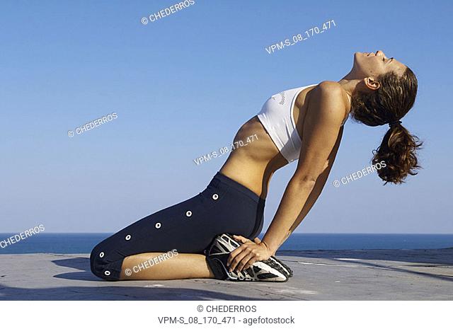 Side profile of a young woman doing yoga