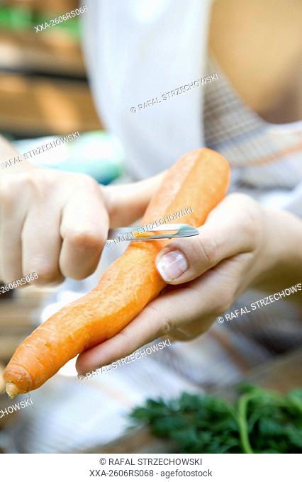 closeup of woman peeling carrot