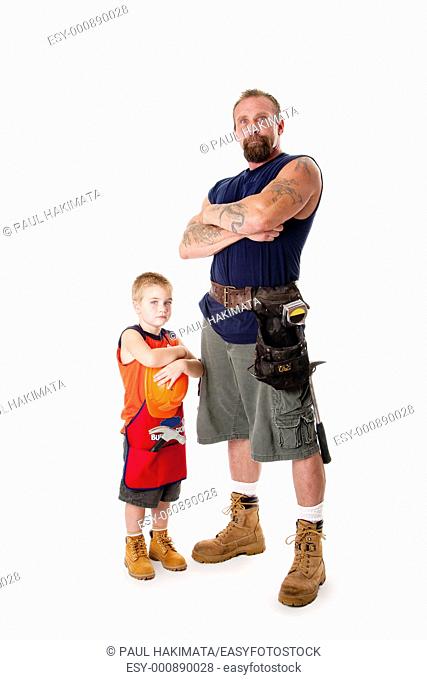 Caucasian middle aged father and cute young son ready to do a construction job  Man and boy wearing tool belt with hammer, shorts and boots
