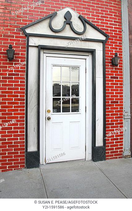 A door surrounded by marble in a ceramic 'brick' facade  Schenectady, New York, United States