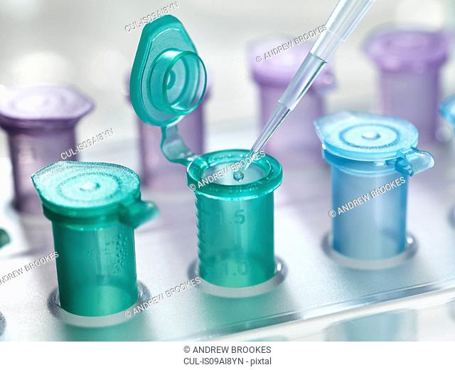 Pipette dropping a solution into a vial, used for storing liquid during chemical or biological research