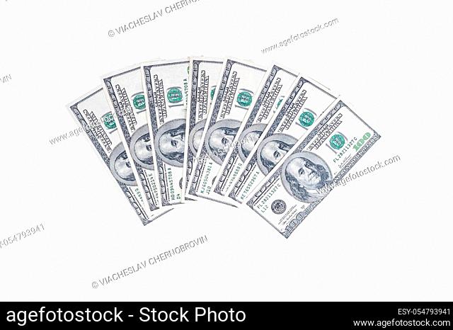 US hundred dollar bills folded in a semicircle with a portrait of American President Benjamin Franklin on an isolated white background