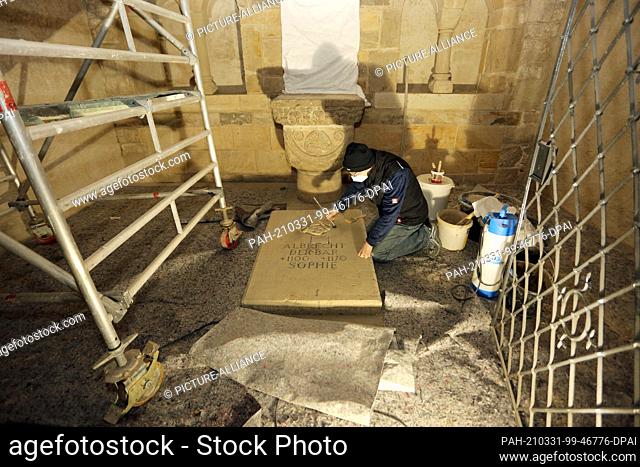 09 March 2021, Saxony-Anhalt, Ballenstedt: Restorer Christoph Hänel cleans a tomb slab in the tomb of ""Albrecht the Bear"" in the former Ballenstedt castle...