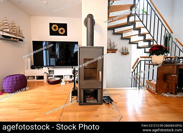 PRODUCTION - 13 December 2023, Bavaria, Munich: A wood-burning stove (single-room fireplace for solid fuels) is installed in a detached house