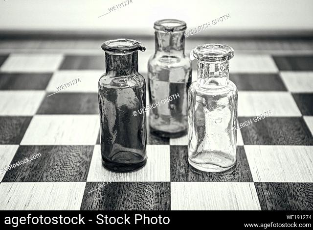 Three bottles in conversation on a chessboard