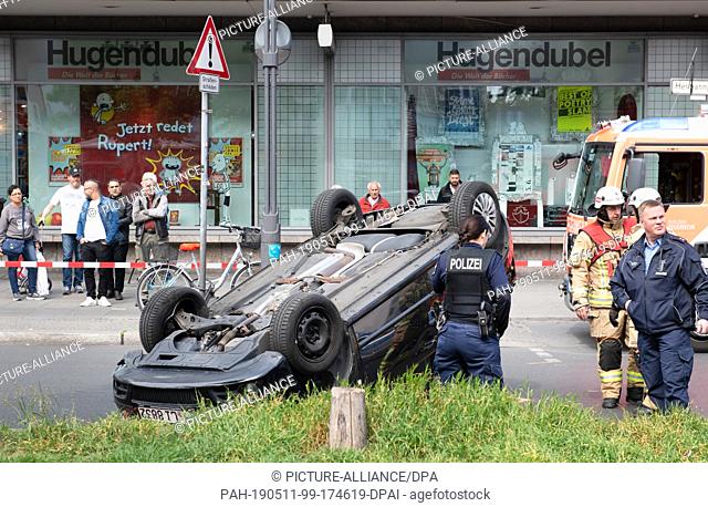 11 May 2019, Berlin: A tilted car is lying on the roof of Hermannplatz in the district Neukölln. For reasons unknown so far