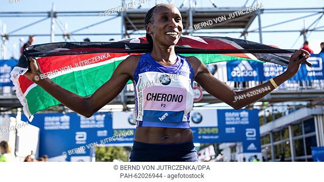 Gladys Cherono of Kenya holds the Kenyan flag in her hands and celebrates after crossing the finishing line as the first female runner during the 42th edition...