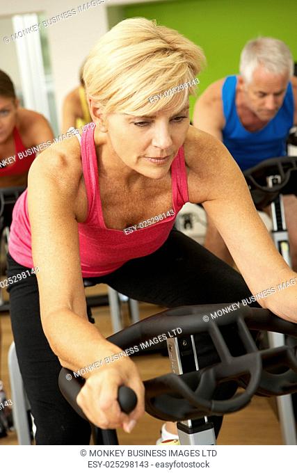 Woman Taking Part In Spinning Class In Gym