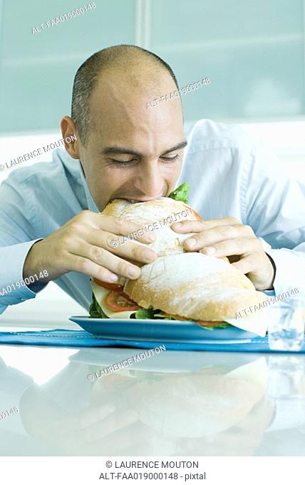 Man biting into large sandwich