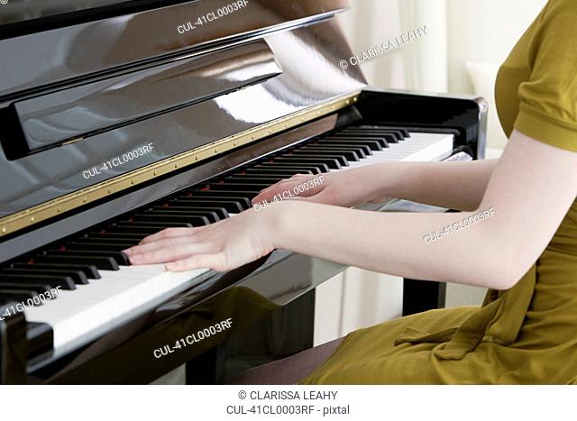 Close up of teenage girl playing piano