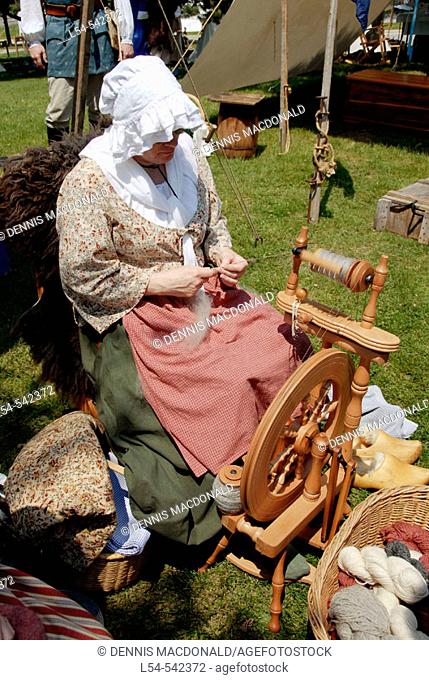 Female spins yarn at Circa 1700 reenactment of the Colonial period lifestyle in Southeastern Michigan at the Feaste of Sainte Claire Port Huron Michigan