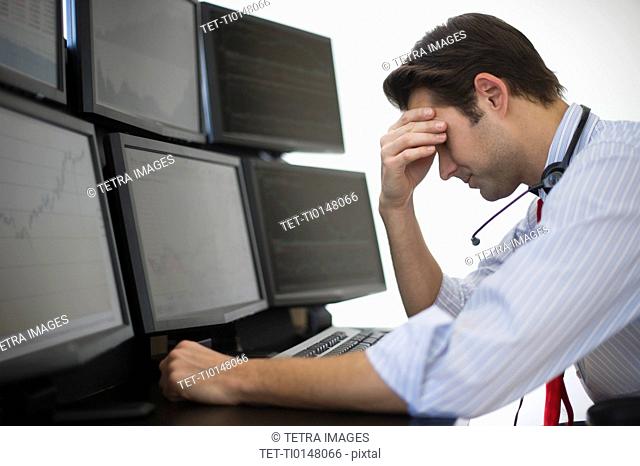 Upset financial worker analyzing data displayed on computer screen
