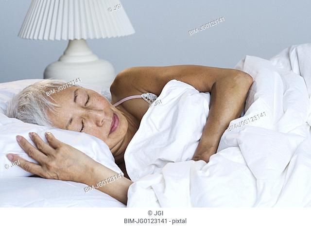 Senior Asian woman sleeping in bed
