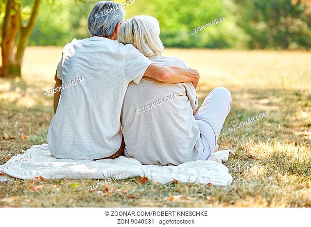 Senioren Paar in Liebe sitzt glücklich im Garten im Sommer