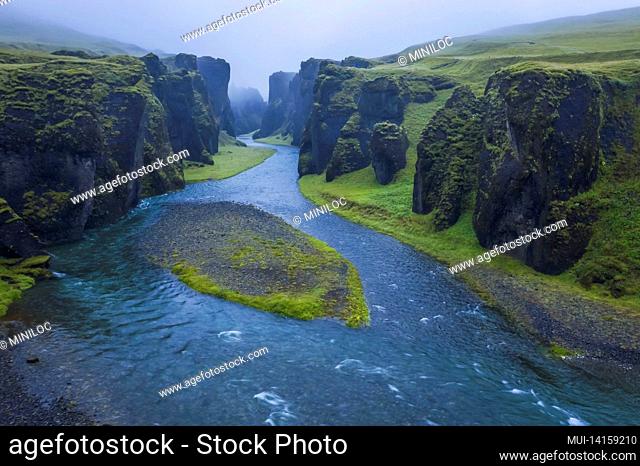 the famous and unique fjadrargljufur valley in iceland on a rainy day. mossy cliffs and mountain river. point of interest for tourists coming to visit iceland