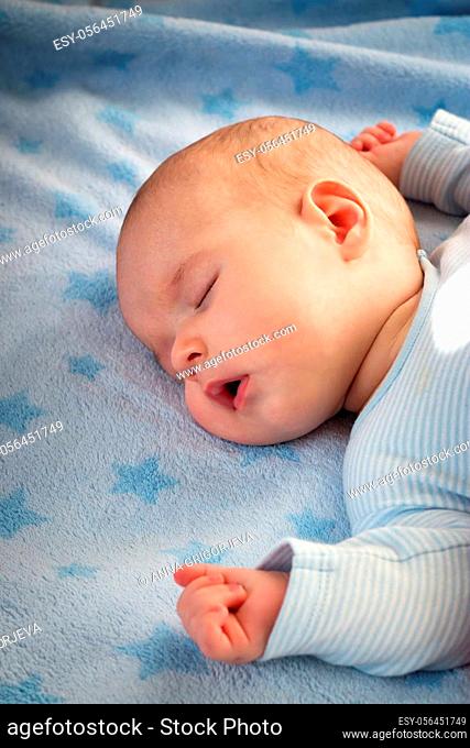 3 month old baby sleeping on blue blanket with stars