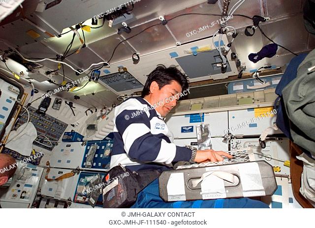 Japan Aerospace Exploration Agency (JAXA) astronaut Takao Doi, STS-123 mission specialist, prepares to eat a meal at the galley on the middeck of Space Shuttle...
