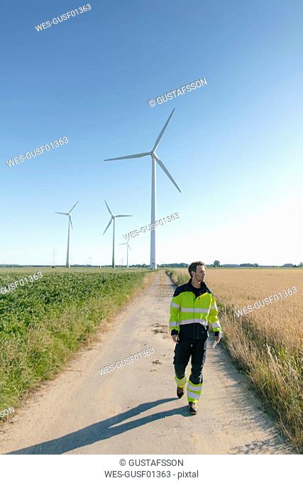 Engineer walking on field path at a wind farm