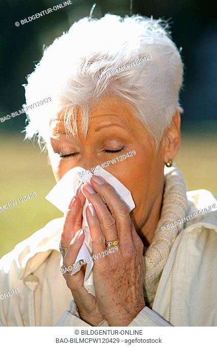 older woman in autumn having a cold