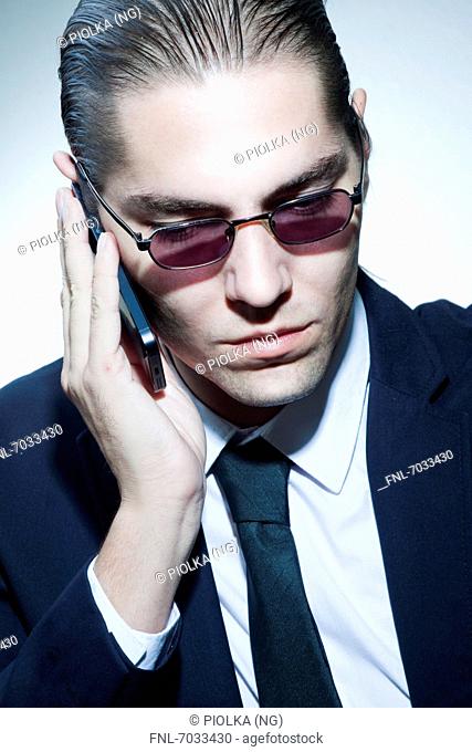 Businessman wearing sunglasses on cell phone