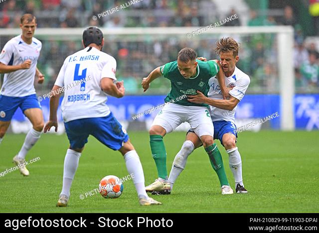 29 August 2021, Bremen: Football: 2. Bundesliga, Werder Bremen - Hansa Rostock, Matchday 5. Werder's Niklas Schmidt fights for the ball against Rostock's Damian...