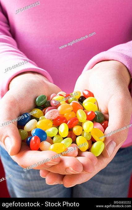 Hands holding coloured jelly beans