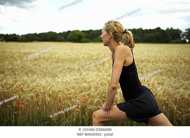 Woman jogging in an open landscape, Sweden