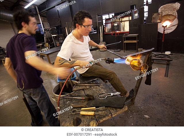 Two glass artists working together with blowtorch