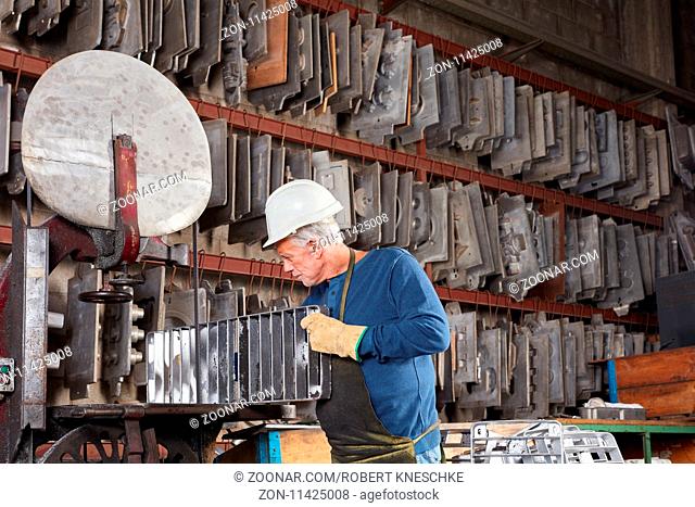 Älterer Mann als Metallarbeiter im Lager für Gussformen in einer Metallfabrik