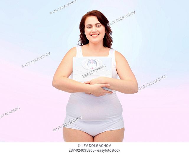 weight loss, diet, slimming, plus size and people concept - happy young plus size woman in underwear holding scales over rose quartz and serenity gradient...