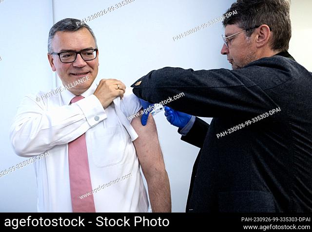 26 September 2023, Bavaria, Munich: Florian Herrmann (l, CSU), head of the Bavarian State Chancellery, gets a flu vaccination from Wolfgang Ritter
