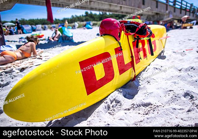 15 July 2021, Mecklenburg-Western Pomerania, Prerow: A DLRG water rescue board stands ready for action next to the pier on the Baltic coast