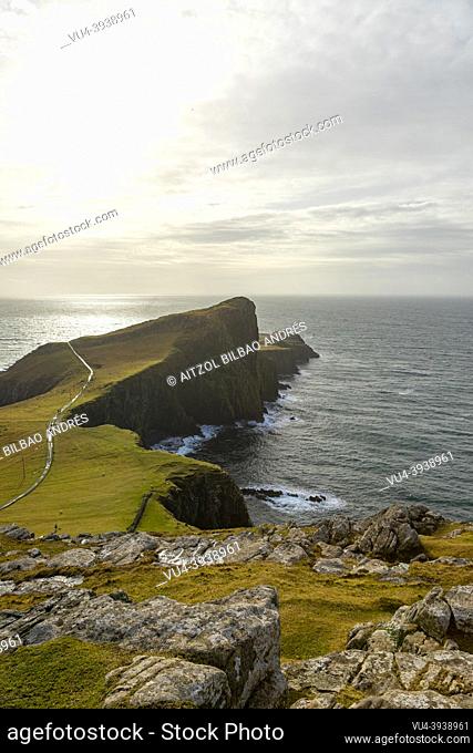 Neist Point Lighthouse, big cliff, cloudy day, sun rays, Skye Island, Highlands, Scotland