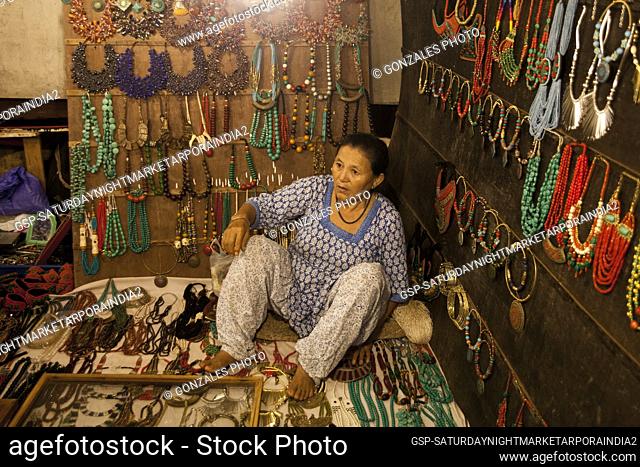 Woman selling different kinds of jewelry at the Saturday Night Market in Arpora, India. The market is open every Saturday during the tourist Season