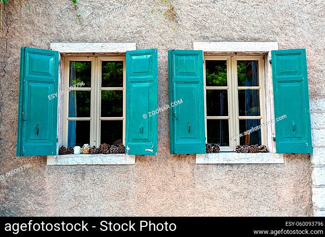 The old window with shutters in the wall of an ancient house. Towm on Lake Garda is the largest lake in Italy. It is located in NorthernItaly