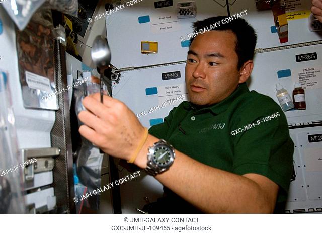 Japan Aerospace Exploration Agency (JAXA) astronaut Akihiko Hoshide, STS-124 mission specialist, prepares to eat a meal at the galley on the middeck of Space...