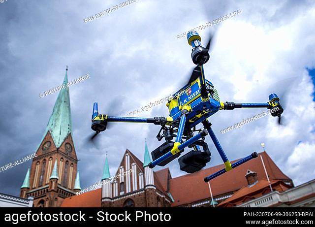 06 July 2023, Mecklenburg-Western Pomerania, Schwerin: A drone with which surveying work is possible hovers on the market square in front of the cathedral at...