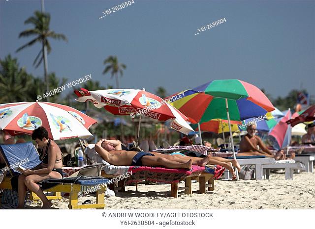 Holidaymakers sunbathing Benaulim Beach Goa India