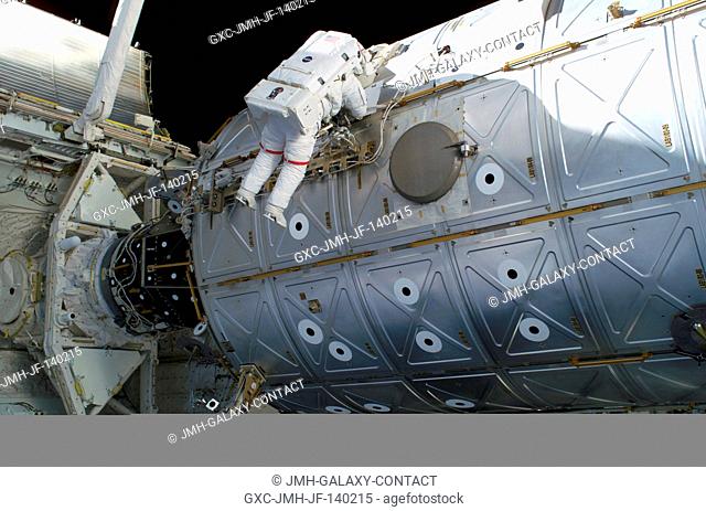 Astronaut Soichi Noguchi, STS-114 mission specialist representing Japan Aerospace Exploration Agency (JAXA), traverses along the Destiny laboratory of the...