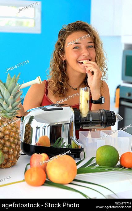 Young woman using a juice extractor