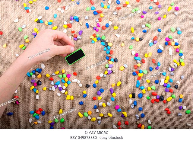 Little noticeboard amid Colorful pebbles spread on canvas