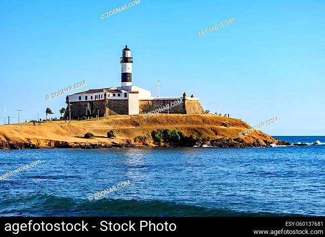 Side view of Barra Lighthouse (Farol da Barra) one of the main historical buildings and tourist spot in the city of Salvador in Bahia surrounded by the sea...