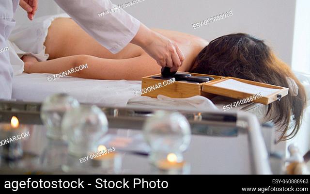 Doctor removes a medical glass cup on the back of a woman, physiotherapy, Tibetan medicine